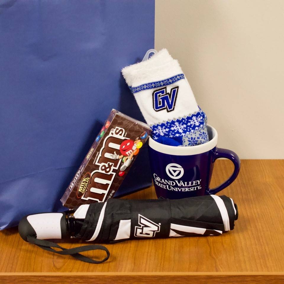 Prize basket including a Grand Valley umbrella, Grand Valley socks, a Grand Valley mug and candy.